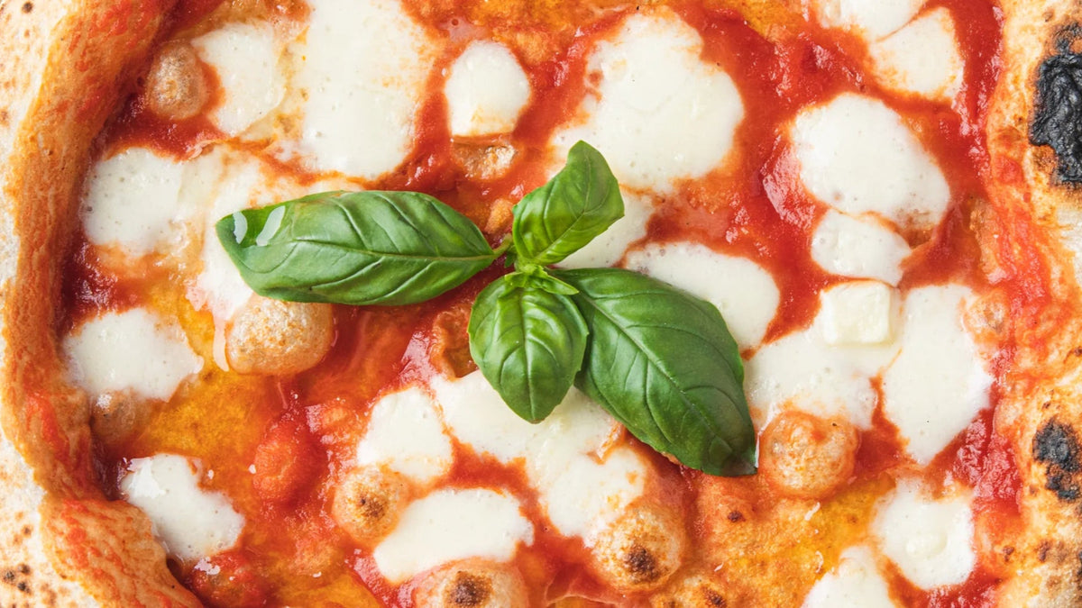 Neapolitan Pizza with basil leaves in center recipe poster image