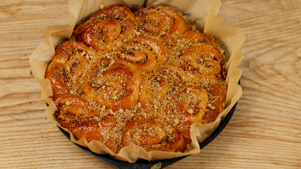 Apple and Ginger Buns in a cast iron pan with parchment paper sticking out the sides recipe poster image