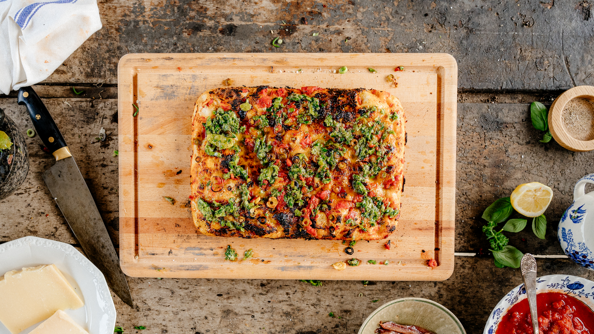 Green Garlic Marinara Pizza Displayed on a Cutting Board