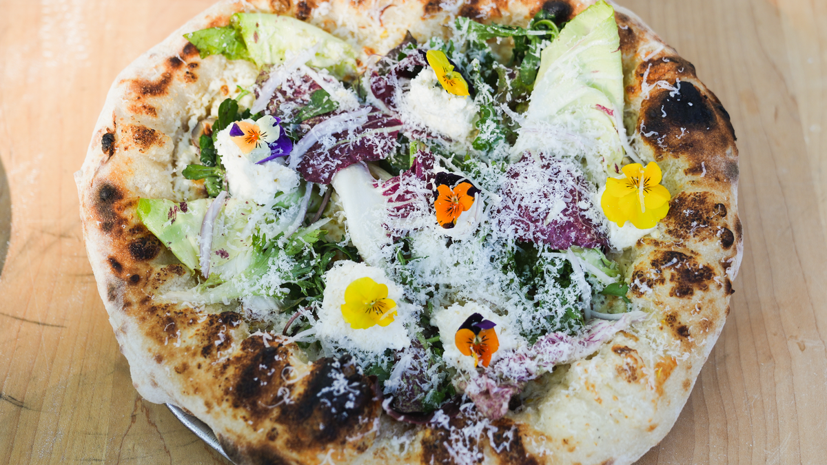 Salad Pizza cooked and presented on wood cutting board recipe poster image